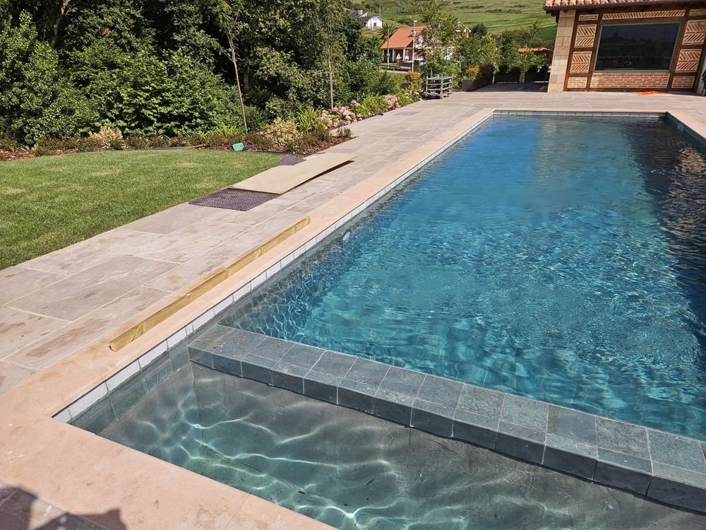 Piscina con gresite oscuro junto a la vivienda