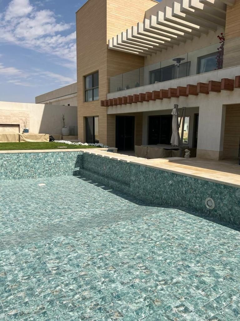 Piscina con gresite junto a vivienda moderna